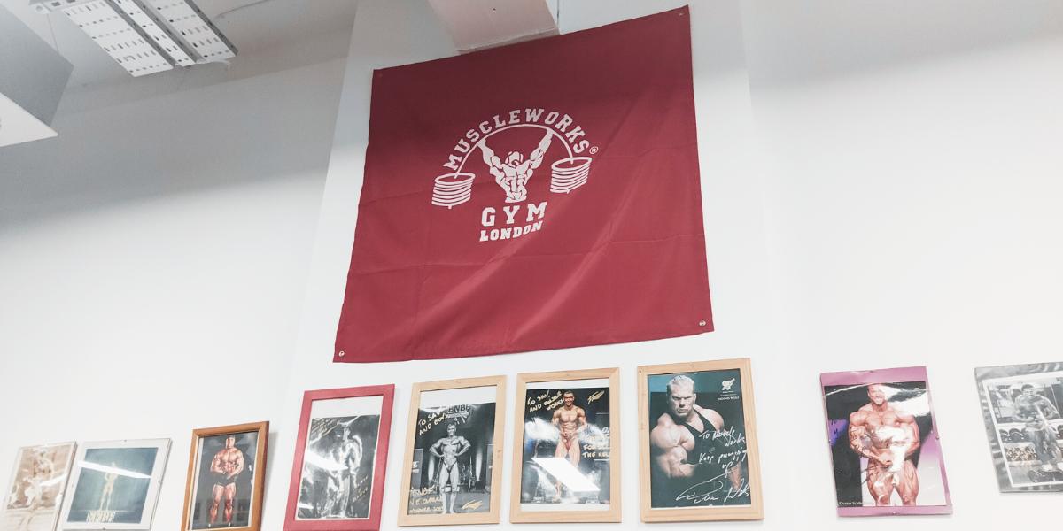 The Muscleworks flag and the wall of classic bodybuilder photos